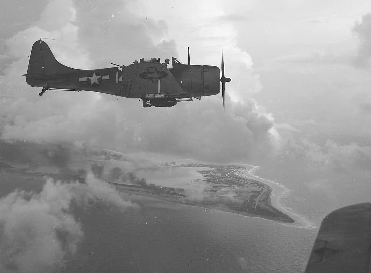 1280px-A_Douglas_SBD_Dive_Bomber_over_Wake_Island,_1943